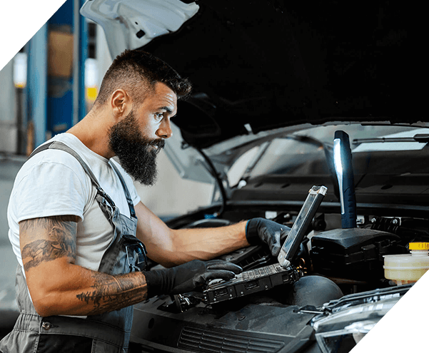 An auto-mechanic in workshop repairs car